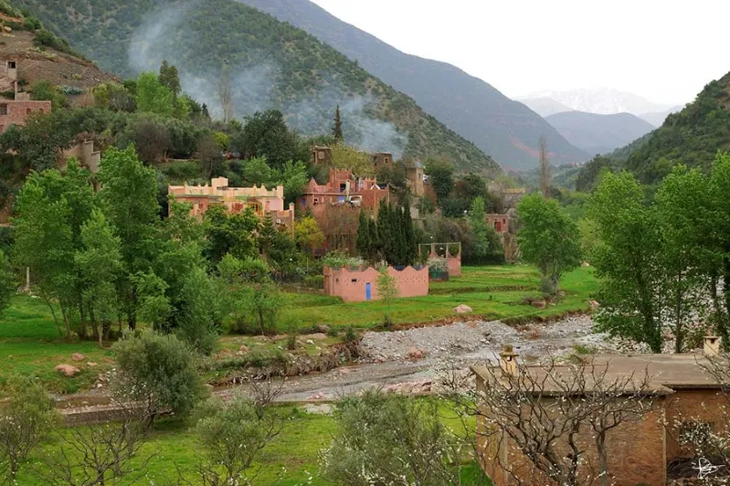 A scenic view of the village of Atlas nestled in the mountains of Morocco's Ourika Valley, showcasing traditional architecture.