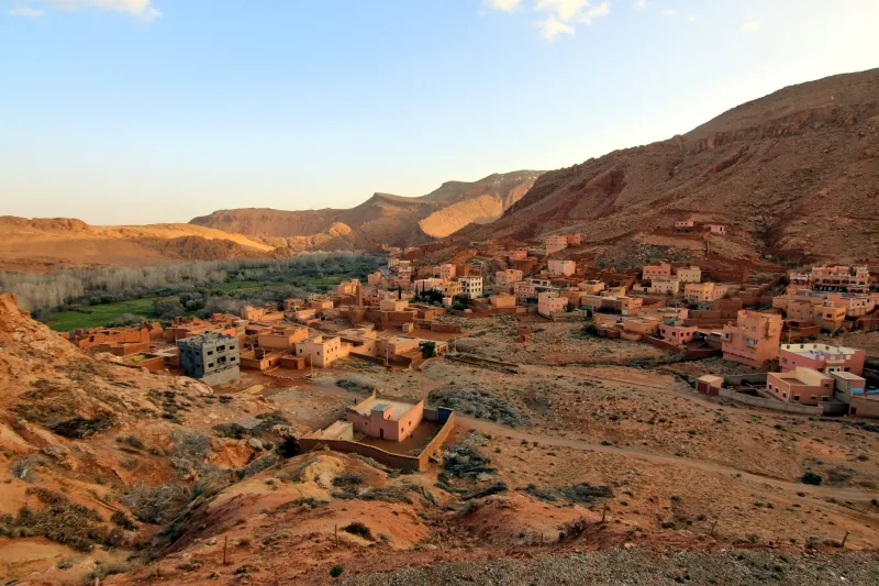 The village of Atlas nestled in the Atlas Mountains, with a backdrop of rugged peaks, near Sahara desert trips from Marrakech.