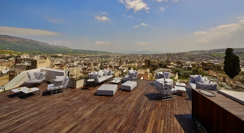 A rooftop terrace with a panoramic view of the cityscape, showcasing the transition from Fes to Marrakech, Morocco.