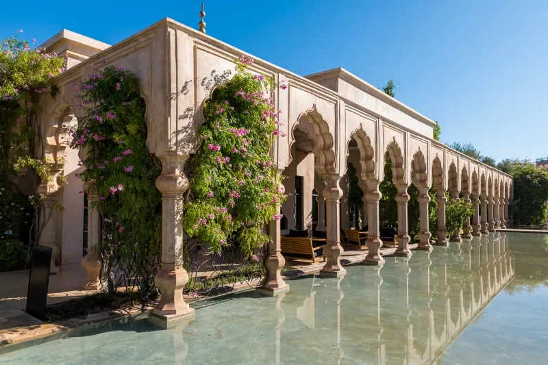 The serene pool at Riad Al-Hamra in Morocco, surrounded by traditional architecture and lush greenery.