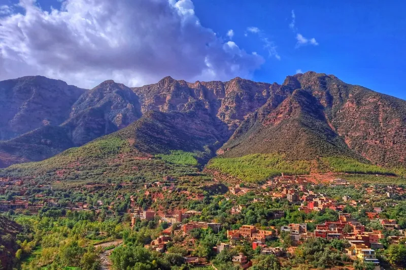 A scenic view of the village of Atlas nestled in the mountains, showcasing its traditional architecture and natural beauty.